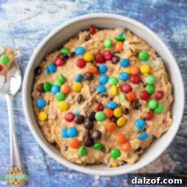 A bowl of Edible Monster Cookie Dough with colorful M&Ms and chocolate chips.