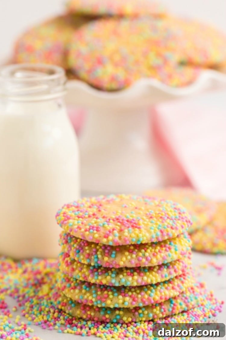 Close-up of cookie dough balls rolled in vibrant Easter sprinkles, ready for baking.