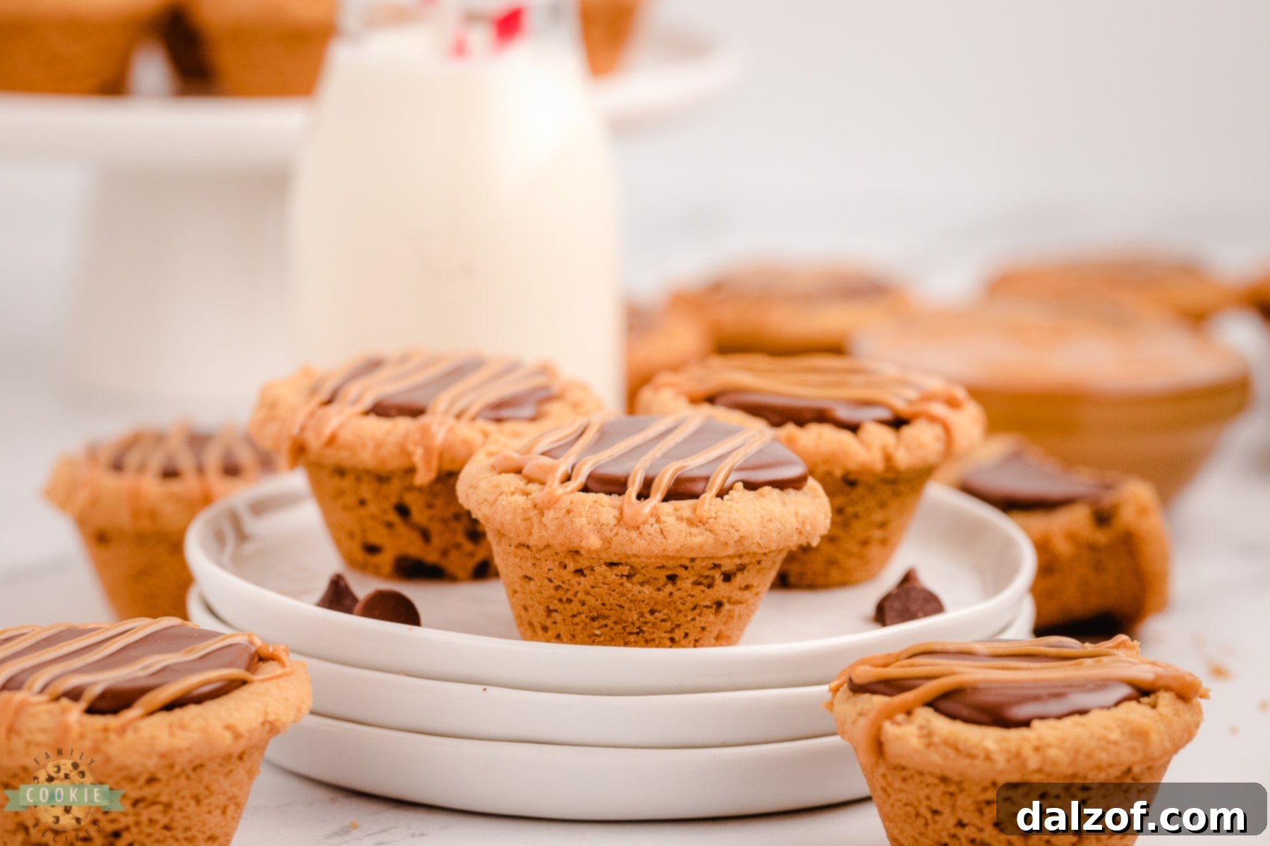 Fudge peanut butter cookie cups served on a white plate with a glass of milk, a perfect snack