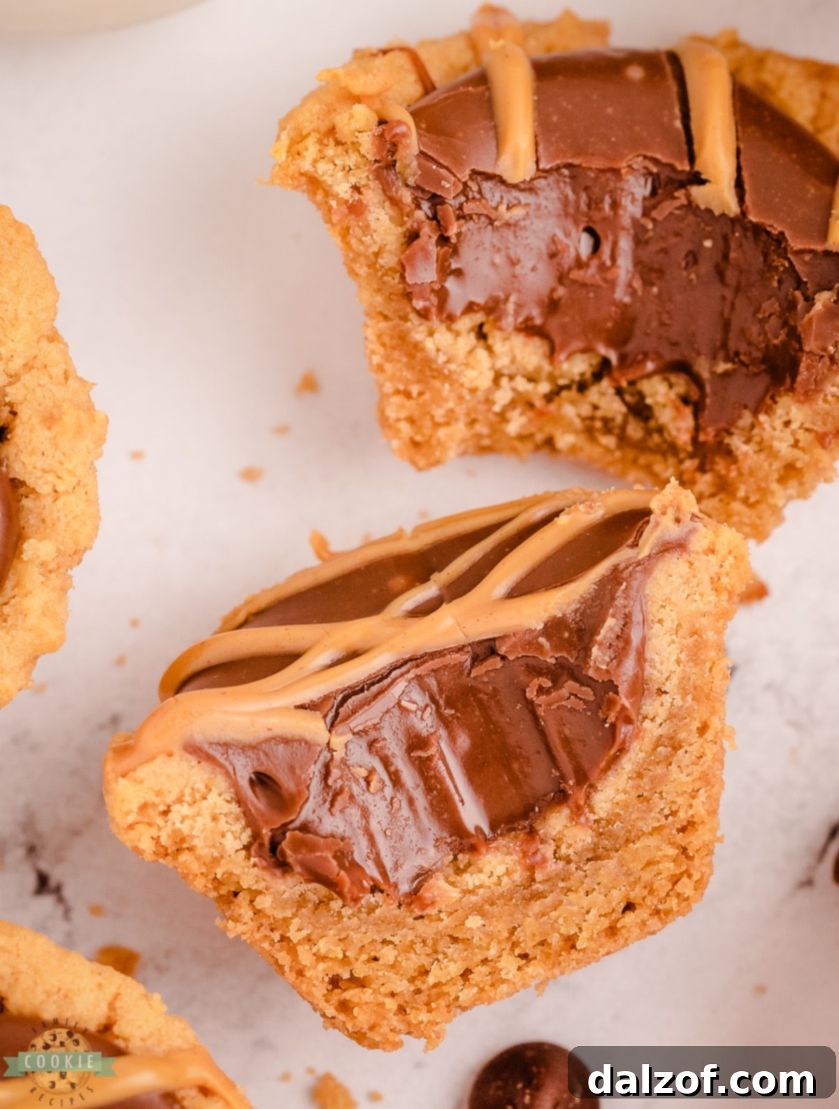 A peanut butter fudge cookie cup with a bite taken out, revealing the creamy fudge interior