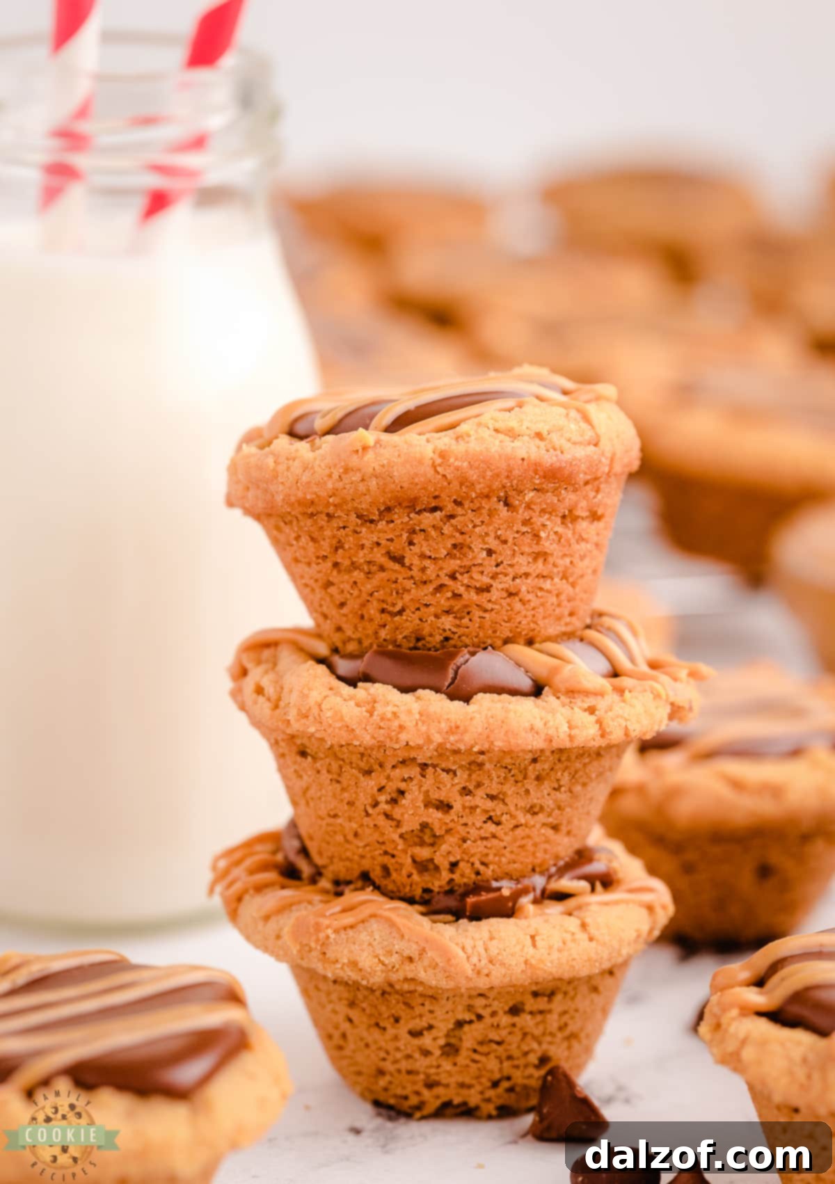 Finished fudge peanut butter cookie cups arranged on a white plate with a glass of milk