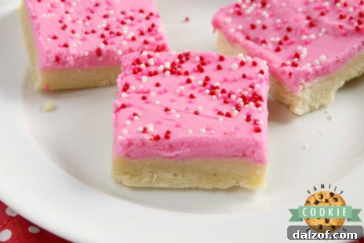 Beautifully frosted sugar cookie bars, perfect for a celebration or a sweet treat, showcasing their thick texture and vibrant sprinkles.