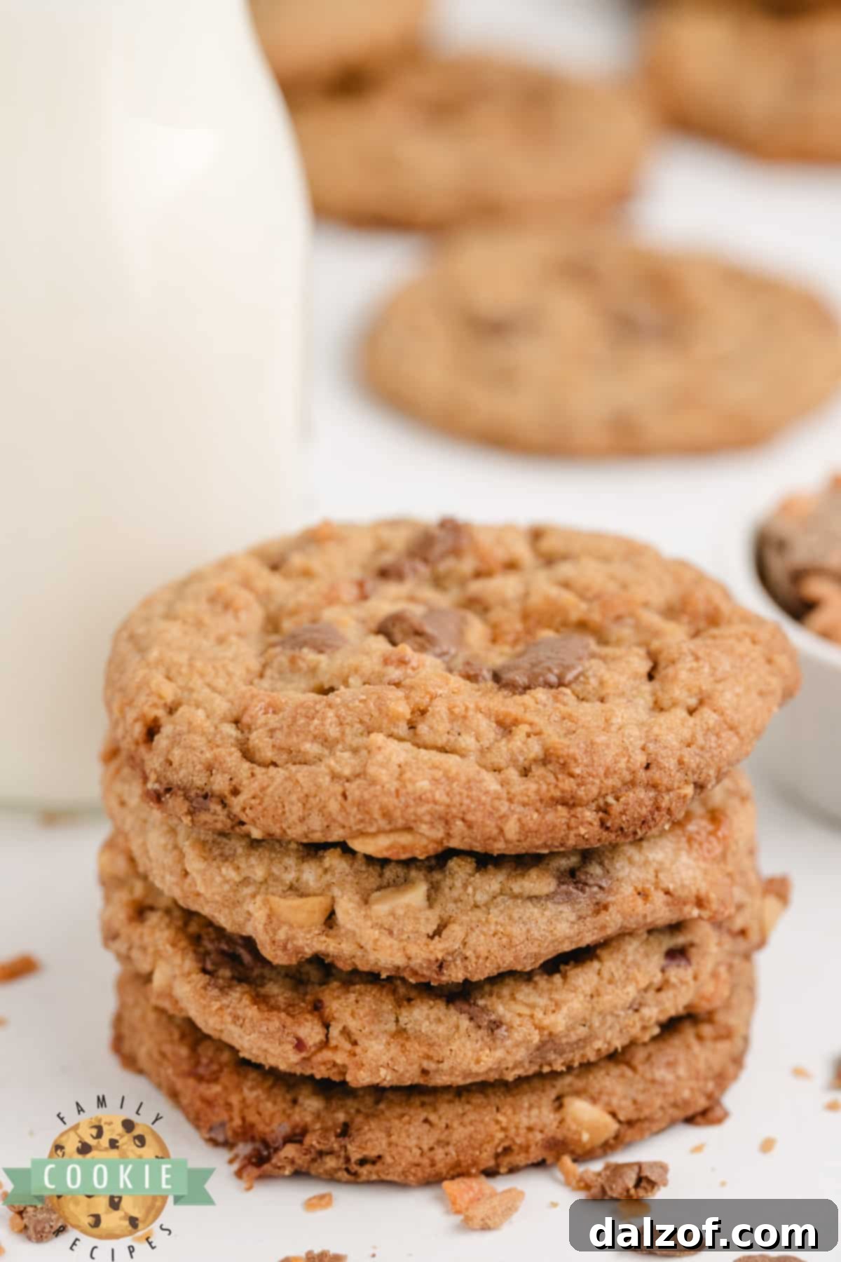 Close-up of a freshly baked peanut butter cookie with Butterfinger chunks on a cooling rack.