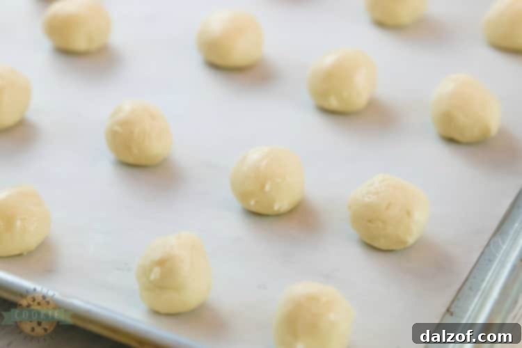 Scooping white cake mix cookie dough into uniform balls