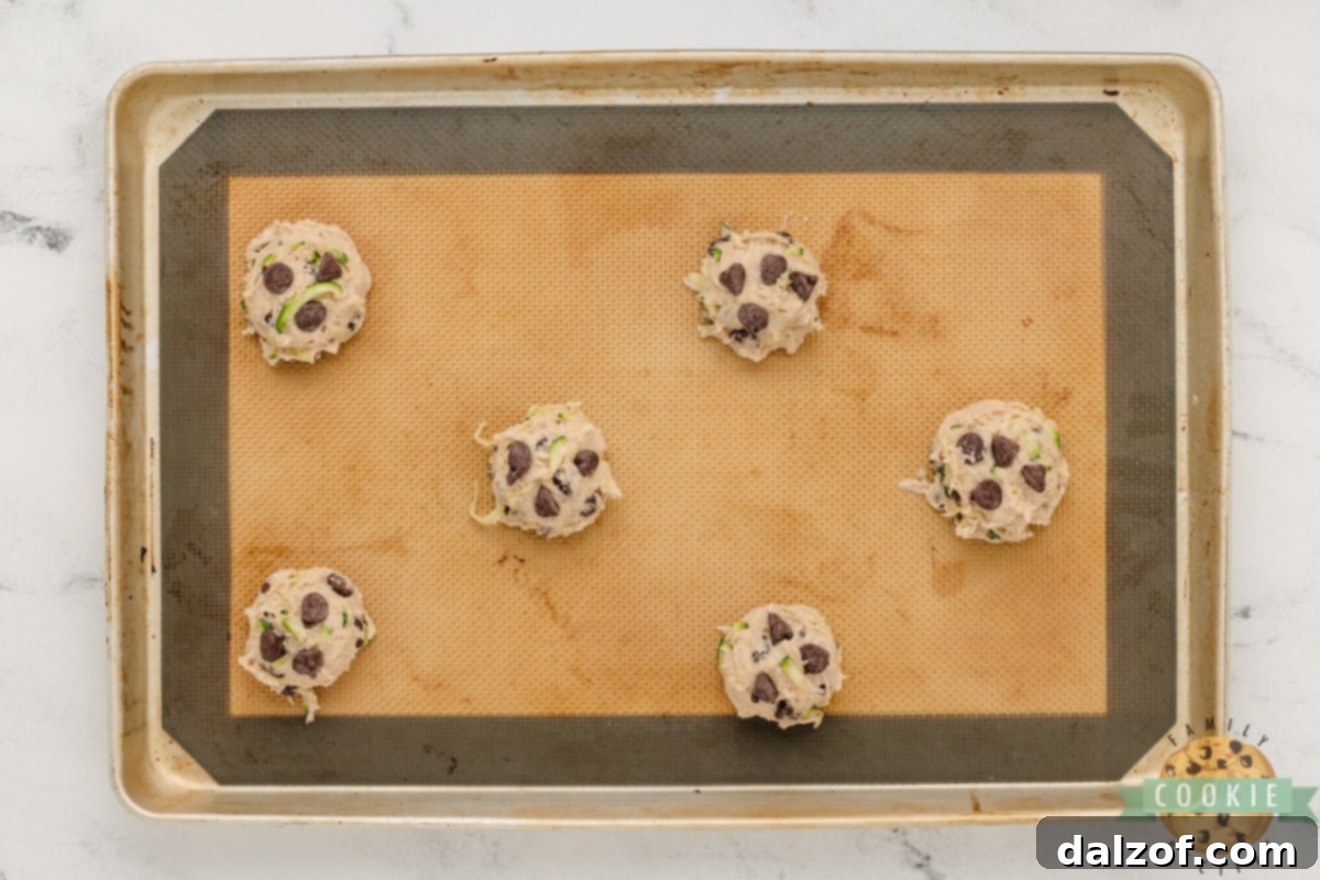 Scoops of cookie dough on cookie sheet. 