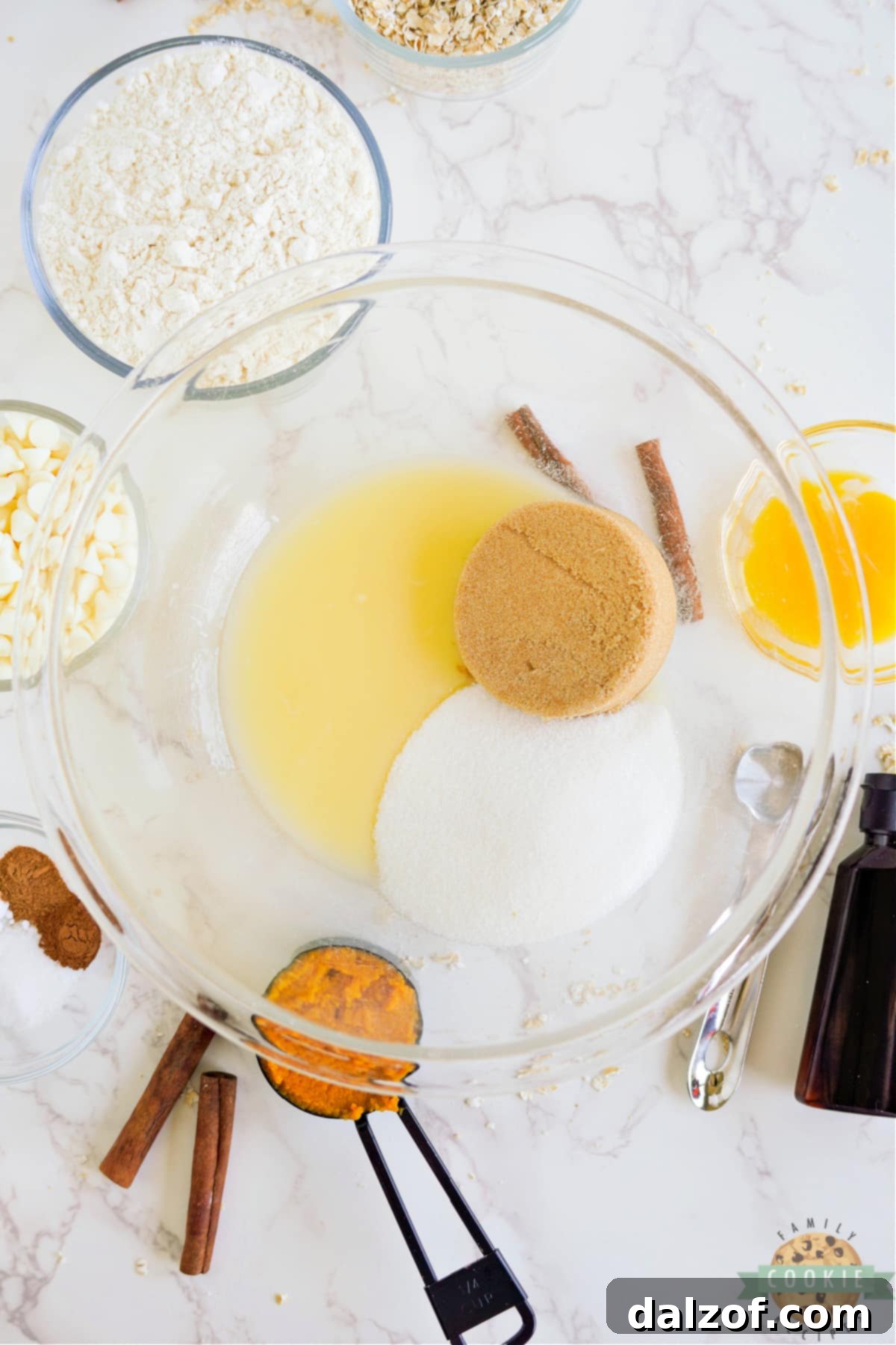 A mixer combining melted butter, white sugar, and brown sugar in a bowl.