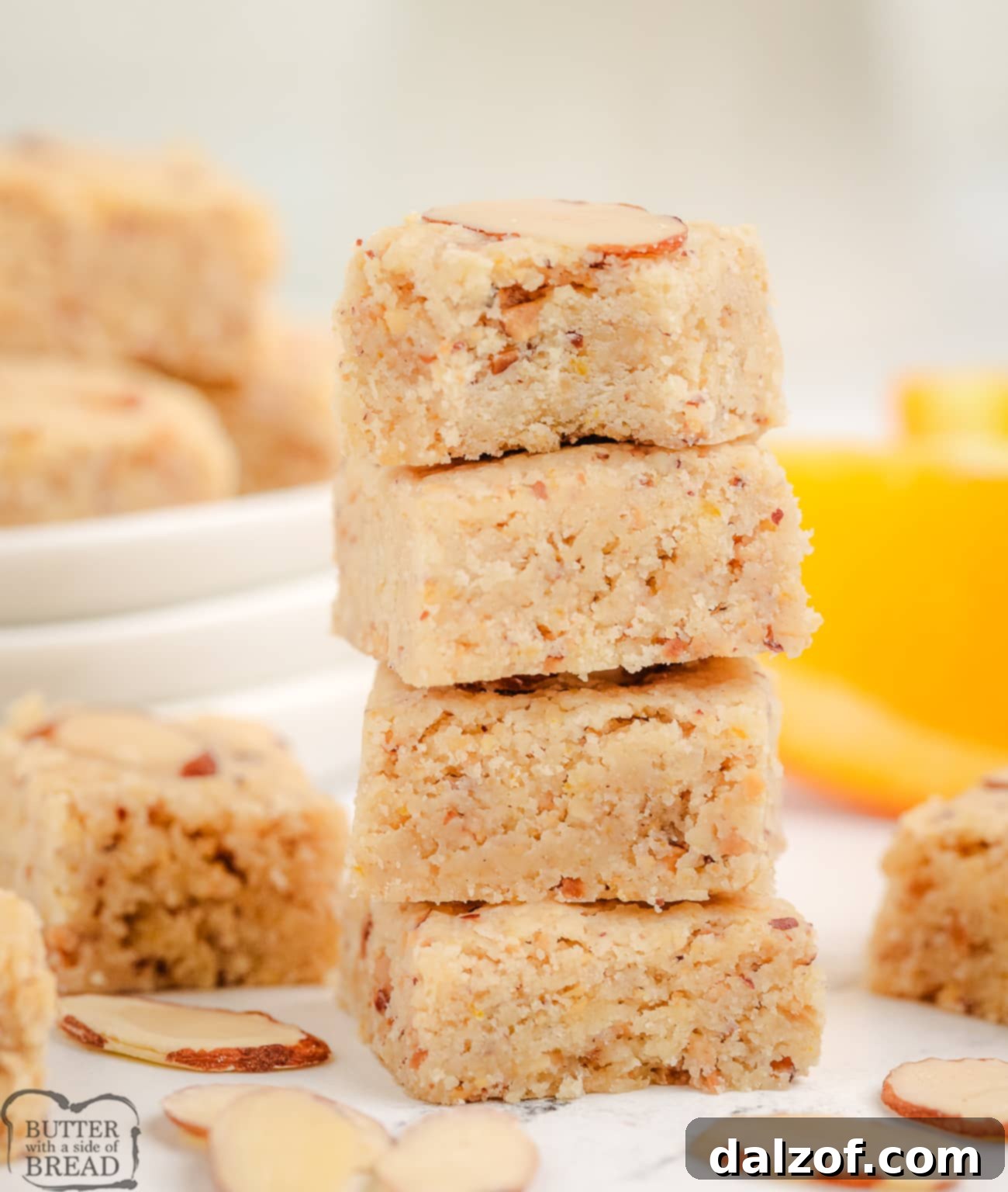 A beautifully arranged stack of golden-brown almond citrus shortbread cookies, highlighting their perfectly square shape.