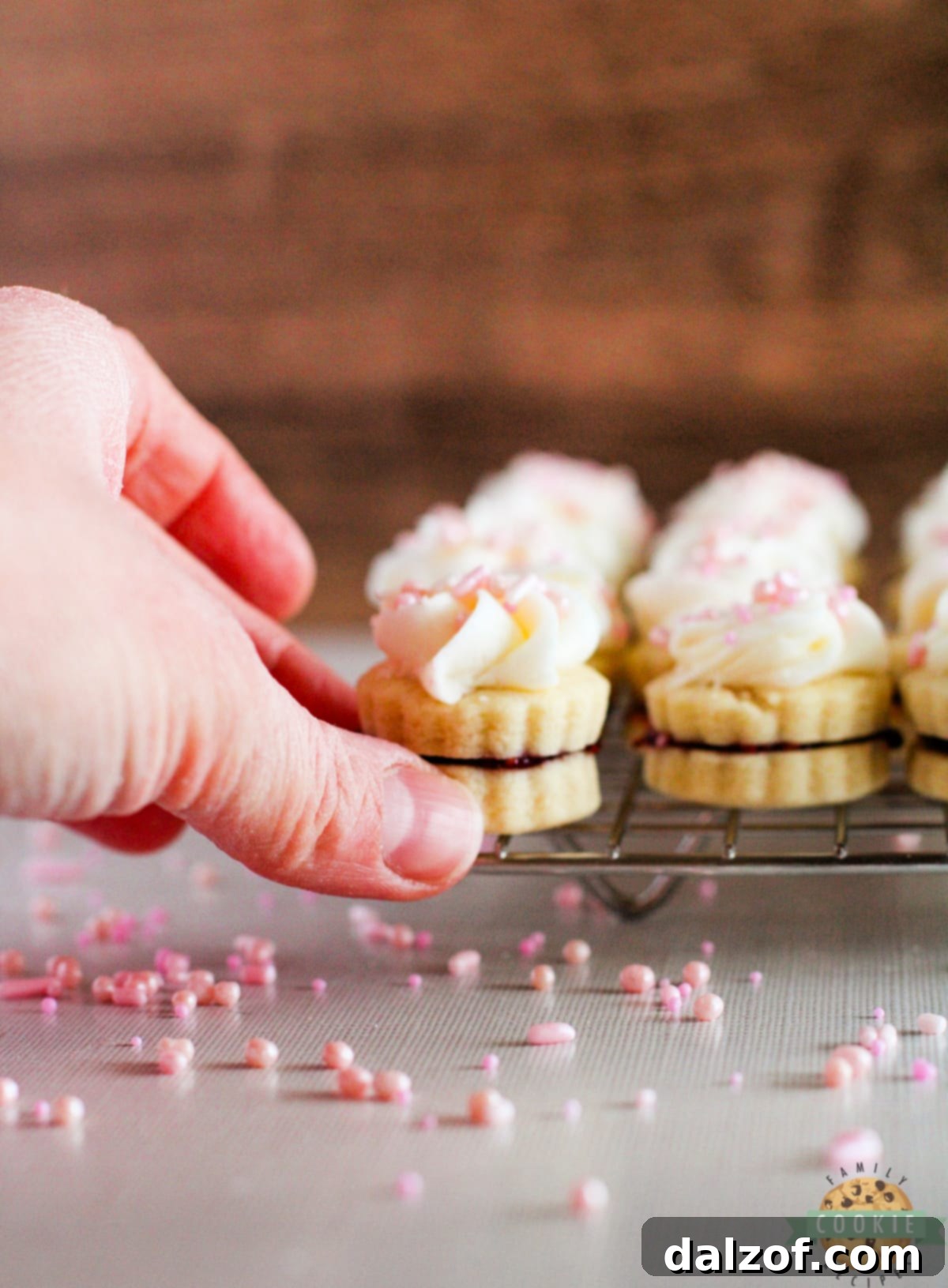 Shortbread cookie sandwiches made with raspberry jam and buttercream frosting. 