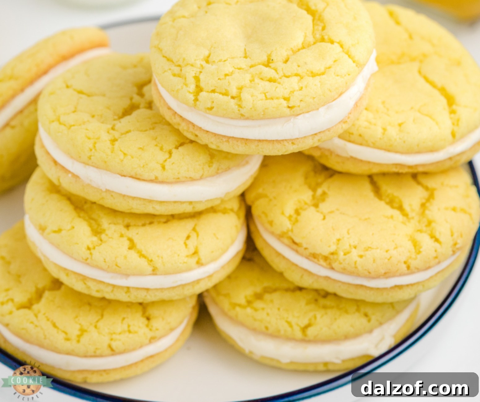 Zesty Lemon Oreo Cake Mix Cookies 5 A stack of assembled homemade lemon oreos on a plate, showcasing the creamy filling between the bright lemon cookies.