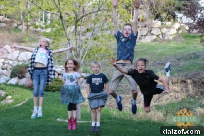 Children happily jumping in a field, symbolizing family fun and outdoor activities.
