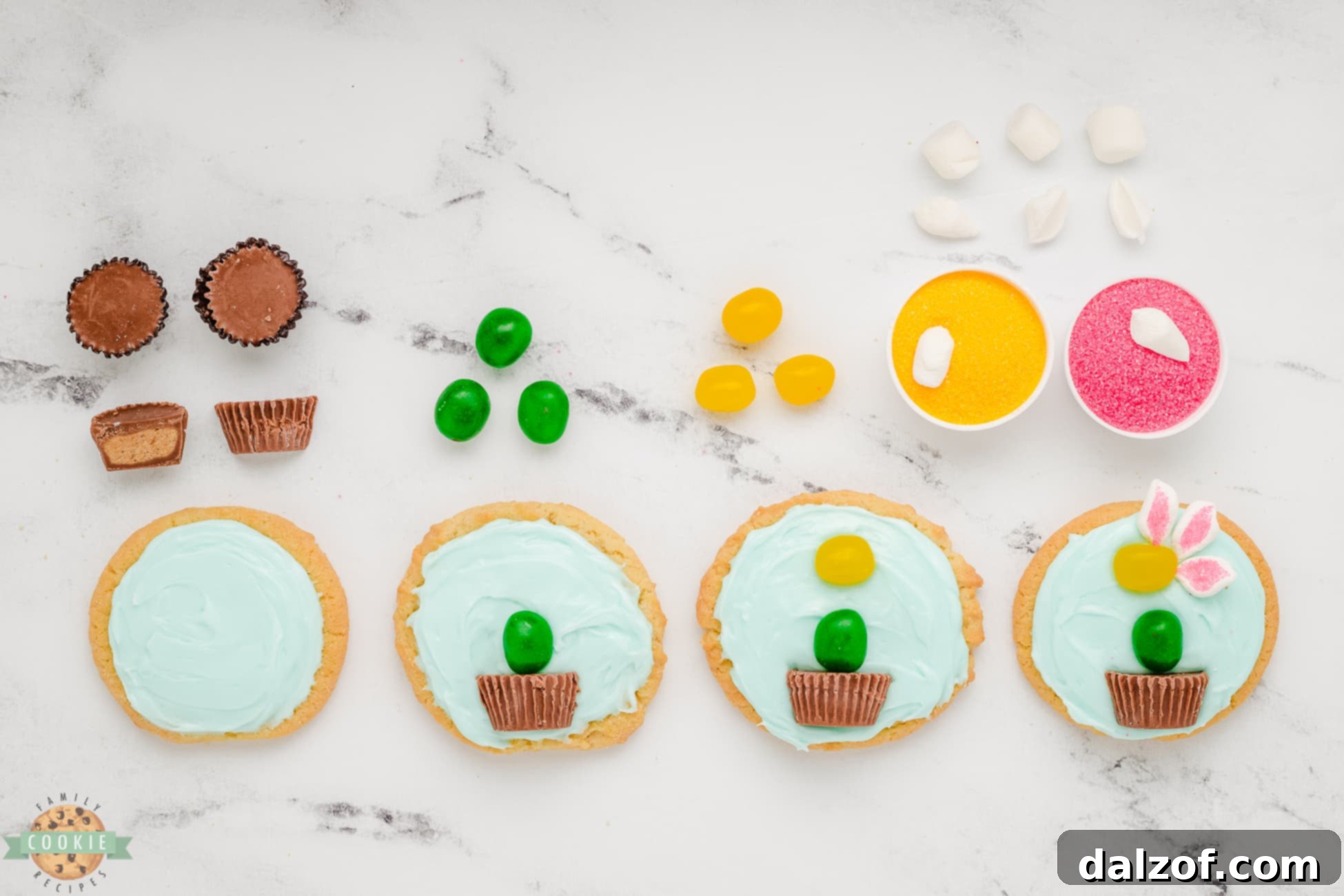 Hands carefully assembling marshmallow flower cookies, placing the marshmallow petals and jelly bean centers onto the blue frosted sugar cookies.