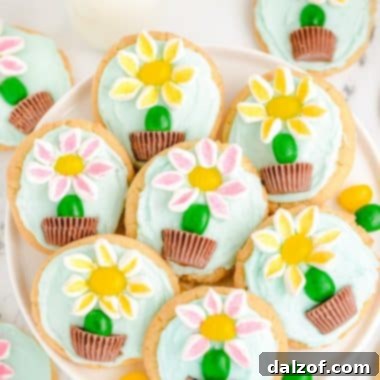 A plateful of beautifully decorated marshmallow flower sugar cookies, perfect for Spring celebrations.