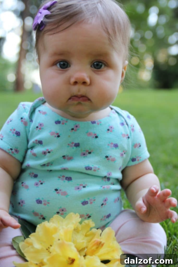 An adorable baby, about a year old, happily playing, showcasing her growth and infectious charm.