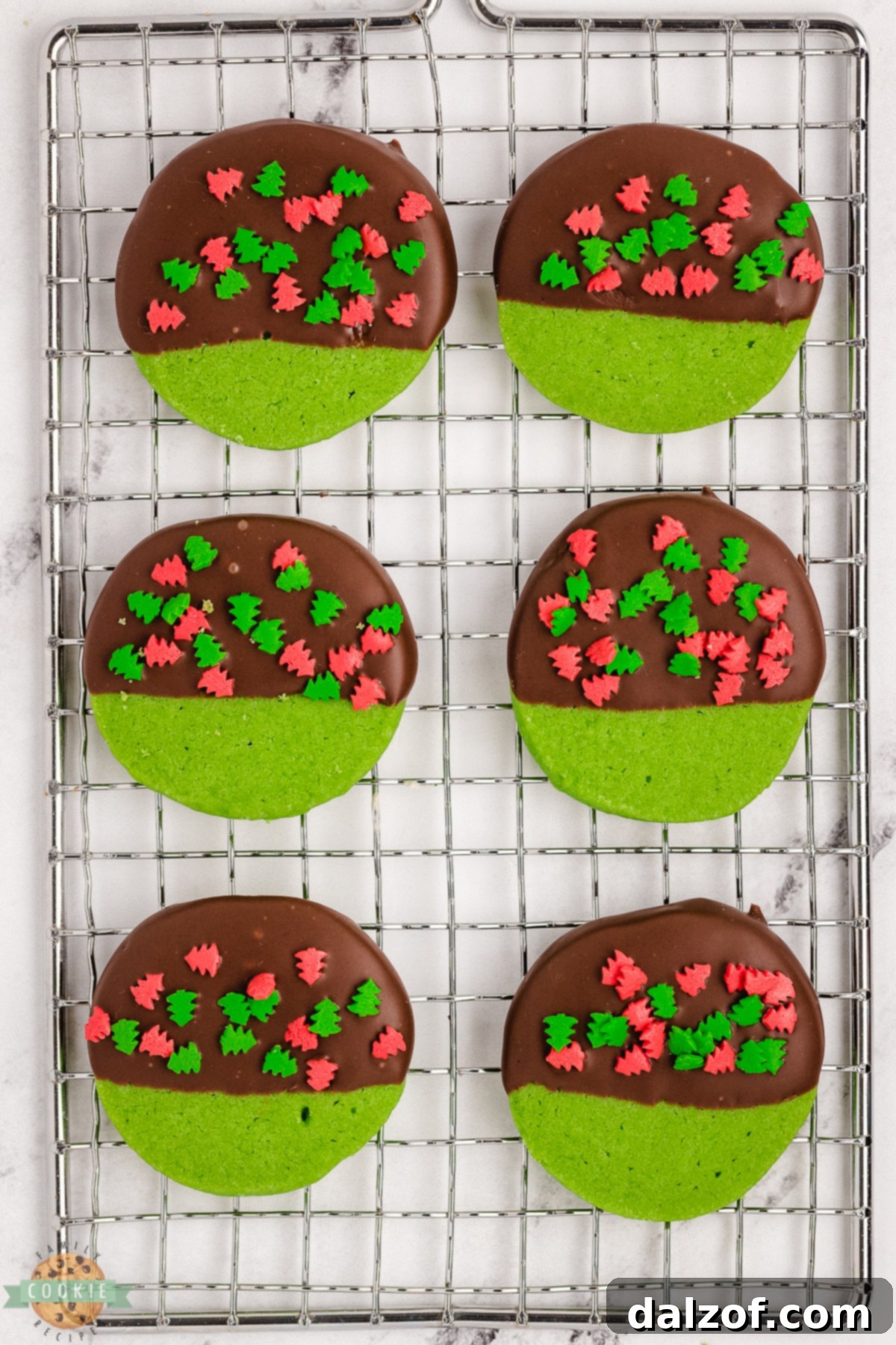 Mint green Christmas cookies, perfectly baked and cooling on a wire rack before dipping.