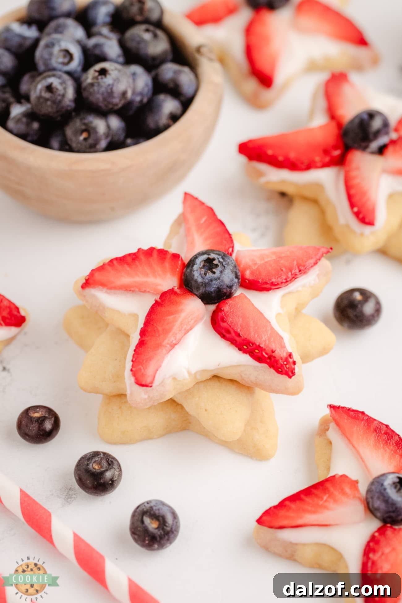 Close-up of buttercream frosted berry star cookies with fresh berries