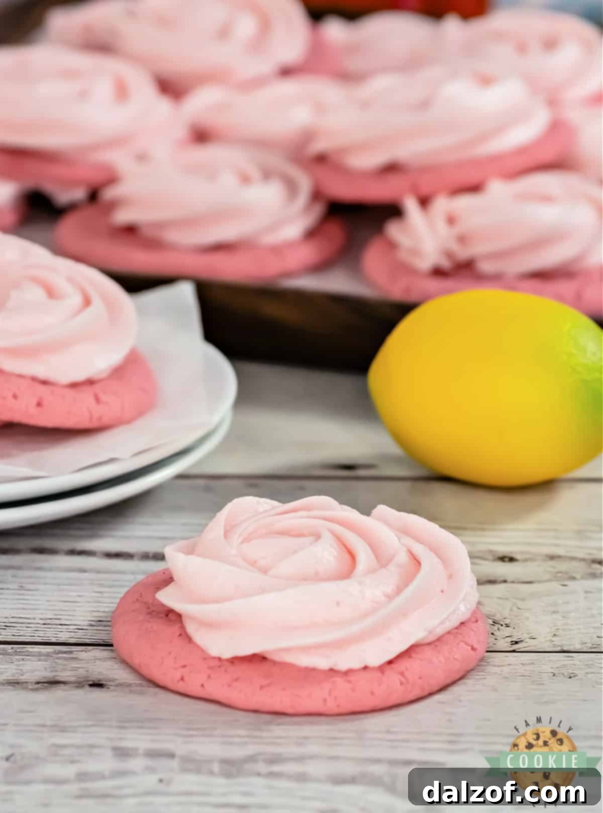 A vibrant display of freshly baked and frosted Pink Lemonade Cookies, arranged beautifully to highlight their appeal as a refreshing dessert.