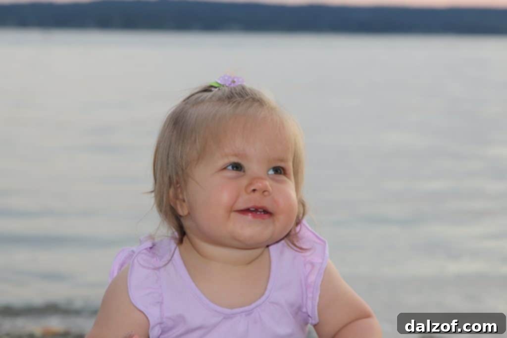 Cute toddler playing near the water at a rocky beach in Western Washington.