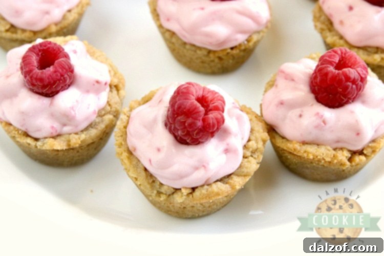 A stunning spread of Raspberry Cheesecake Cookie Cups on a wooden board, showcasing their beautiful presentation