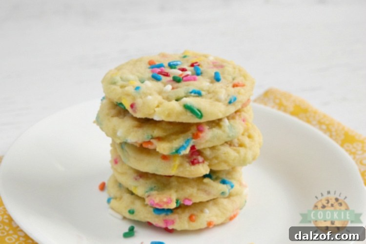 Stack of freshly baked Birthday Cake Cookies on a white plate, highlighting their vibrant sprinkles.