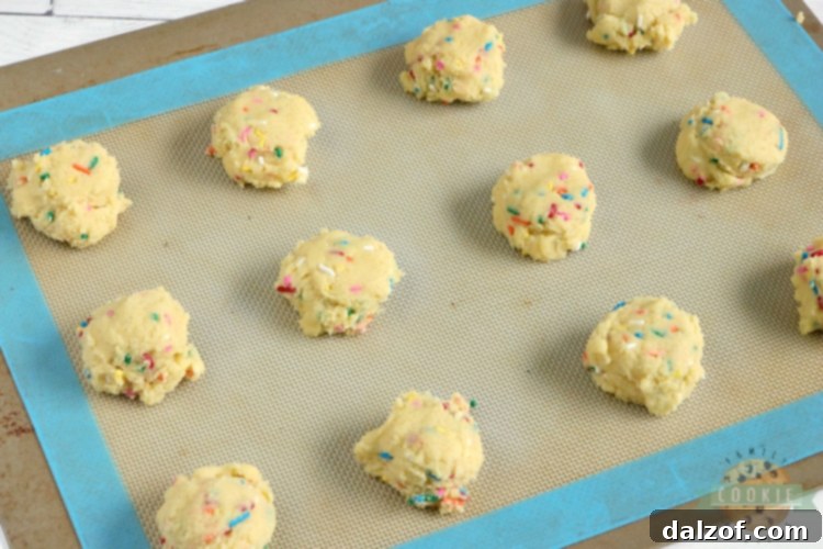 Close-up of baked vanilla cookies with colorful sprinkles, fresh out of the oven.