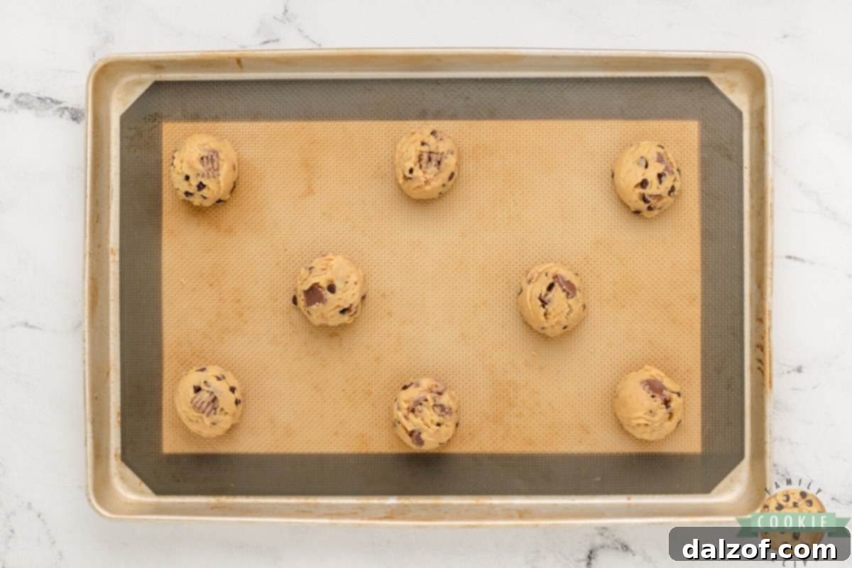 Ultimate Reese Peanut Butter Pudding Cookies 13 Scoop cookie dough onto baking sheet. Rounded scoops of peanut butter cookie dough arranged on a parchment-lined baking sheet, spaced for baking.