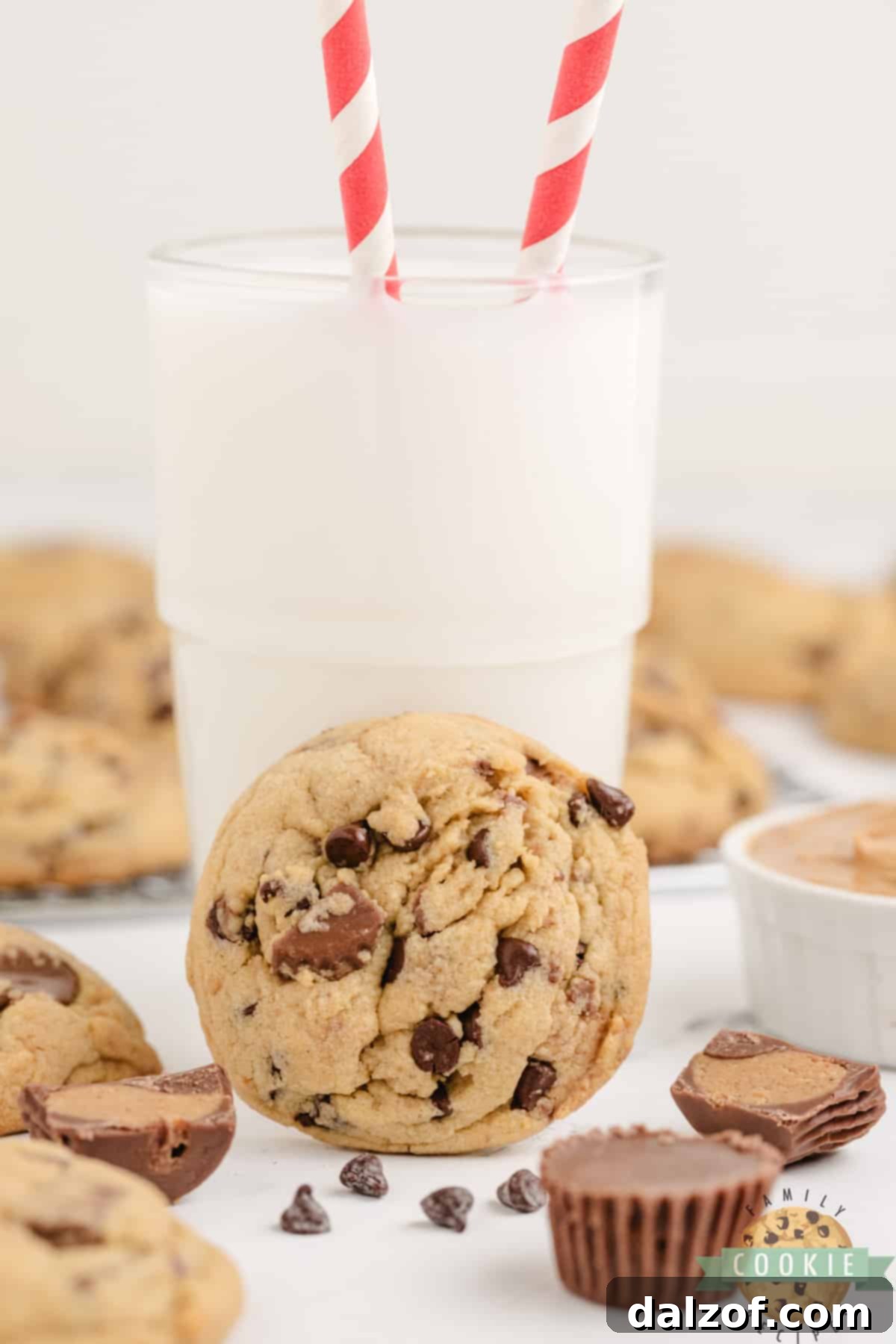 Ultimate Reese Peanut Butter Pudding Cookies 6 Peanut butter cookie with peanut butter cups and a glass of milk. A single, perfectly baked cookie with visible Reese's pieces rests beside a tall glass of cold milk, ready for enjoyment.