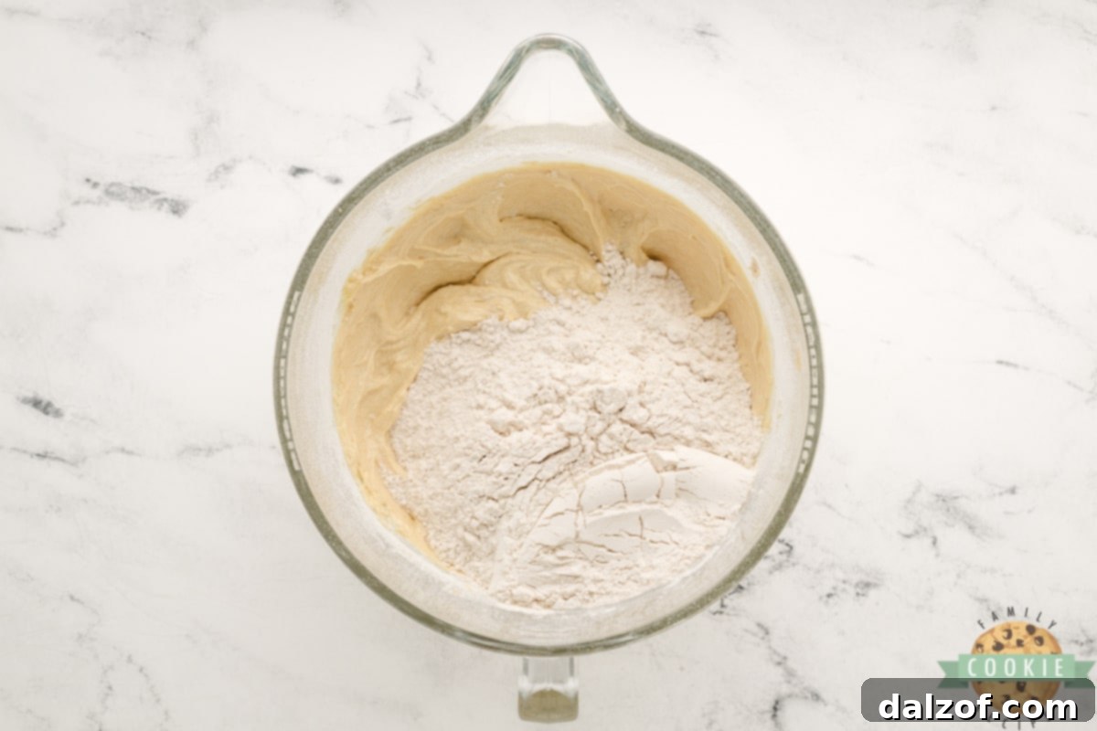 Wholesome Banana Oat Bliss 9 Mixing dry ingredients (flour, baking soda, cinnamon, salt) into wet cookie dough