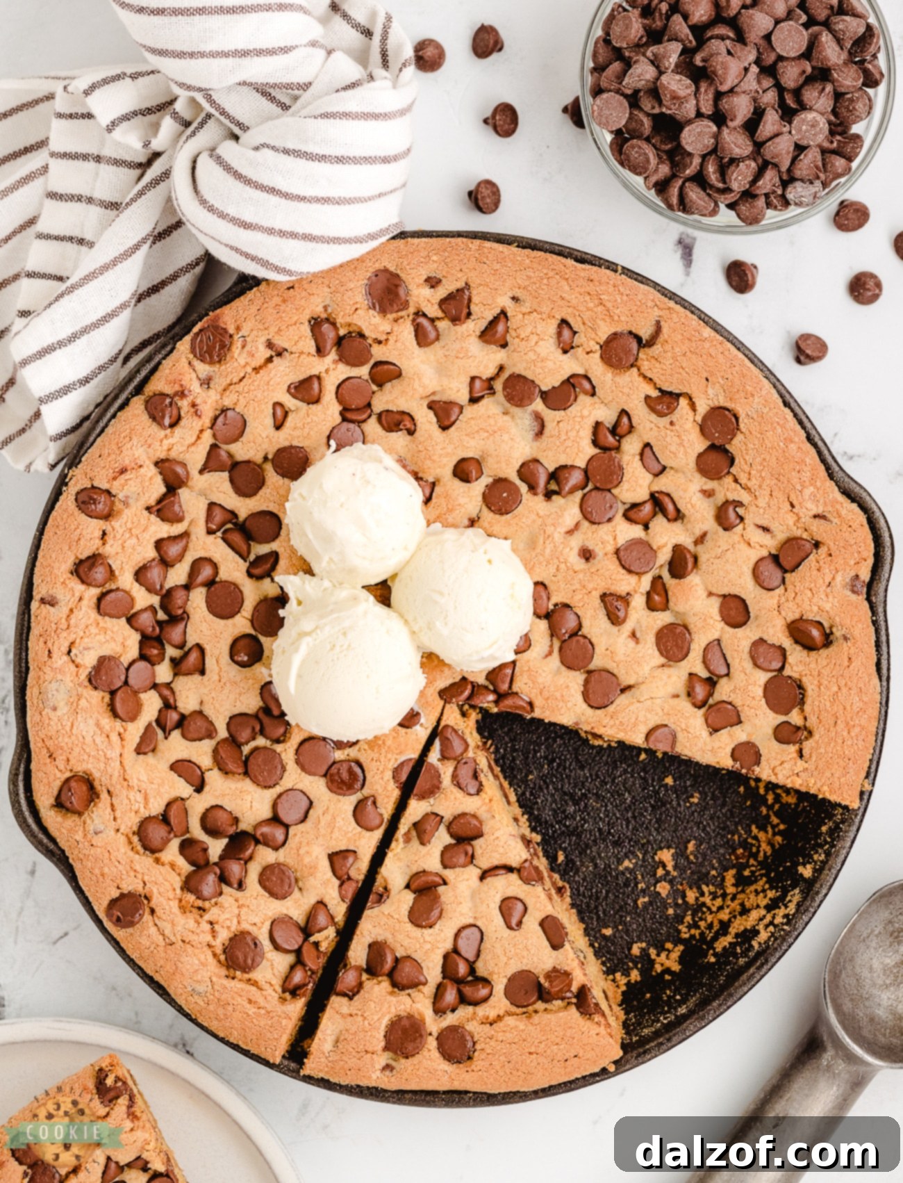 A delicious Cast Iron Skillet Cookie freshly baked and generously topped with scoops of vanilla ice cream, ready to be served.