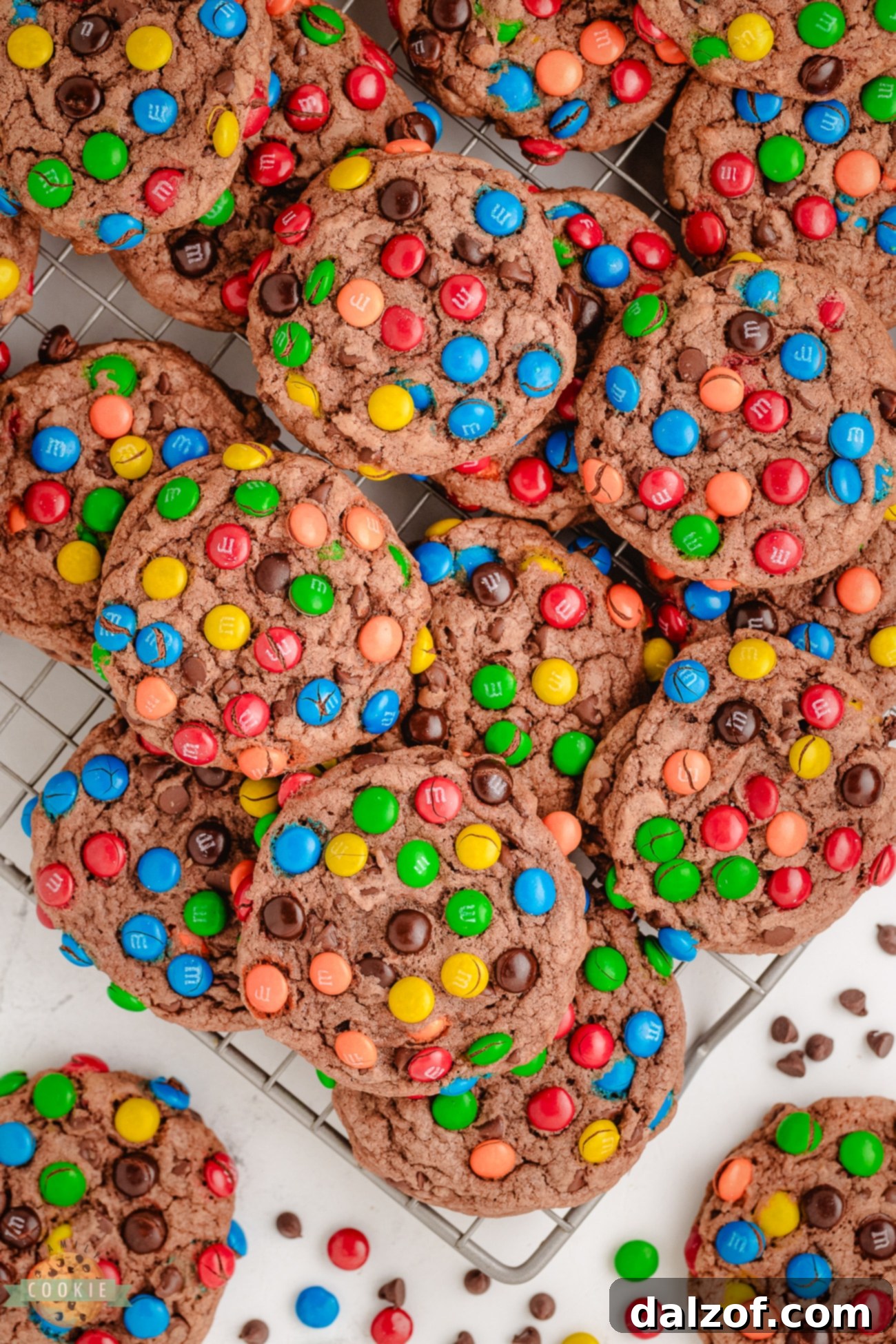 Freshly baked Chocolate Pudding M&M Cookies cooling on a wire rack, still warm and inviting with visible M&M candies on top.