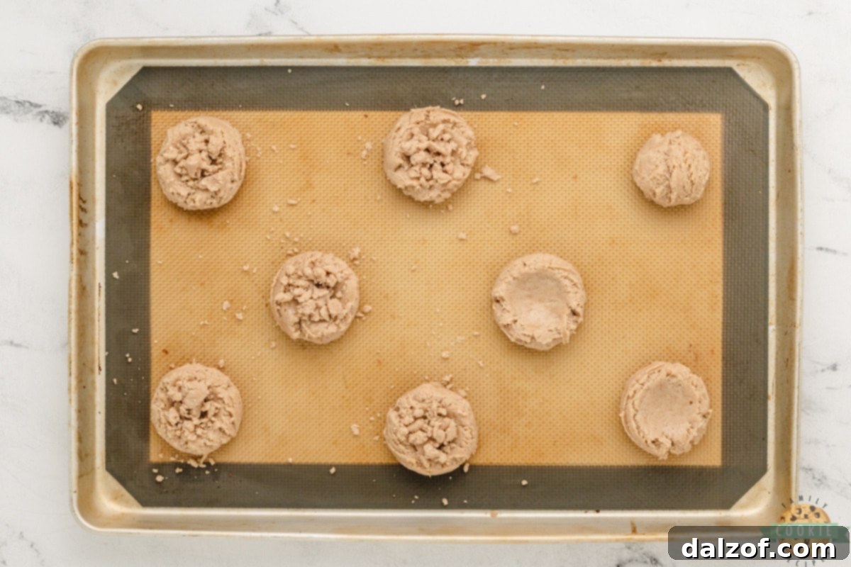 Topping cookie dough with crumb topping before baking.