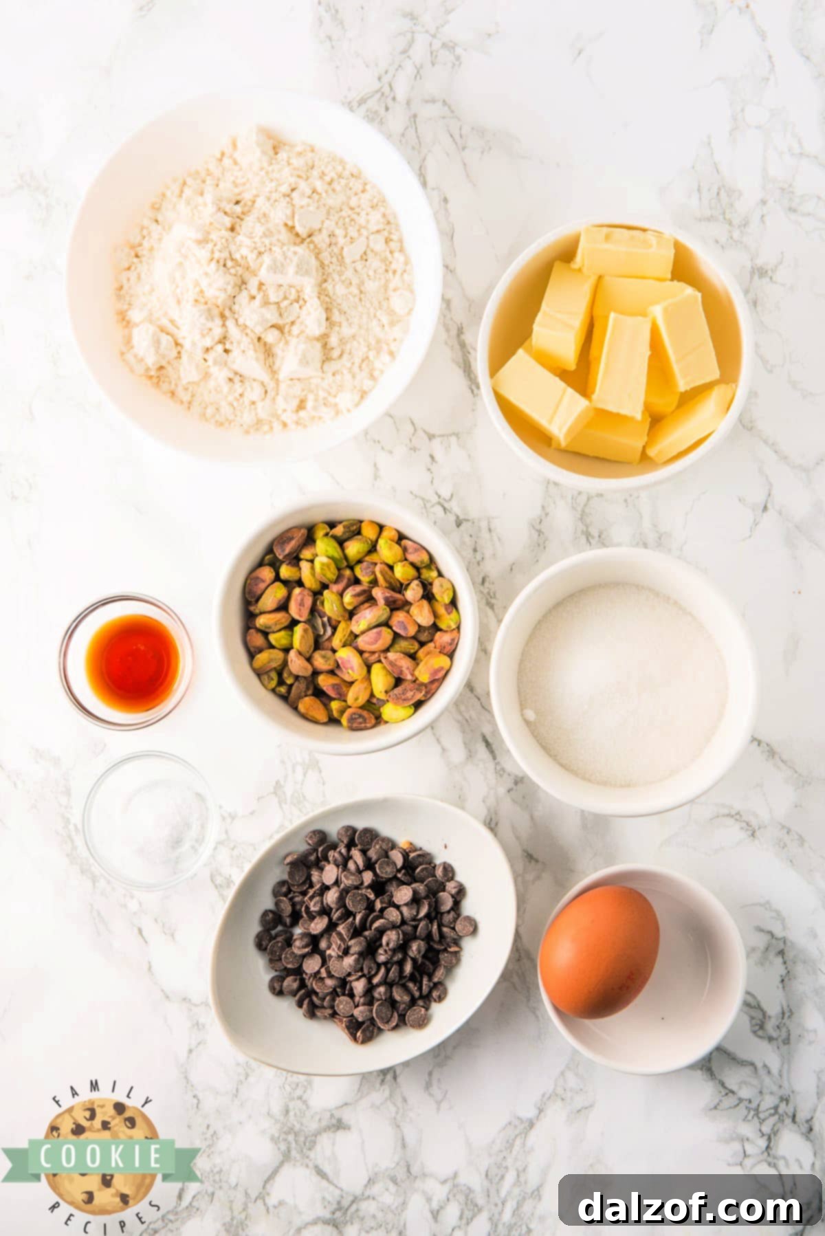 A visual representation of the key ingredients used in Chocolate Dipped Pistachio Cookies, including pistachios, butter, sugar, egg, flour, vanilla extract, and dark chocolate chips.