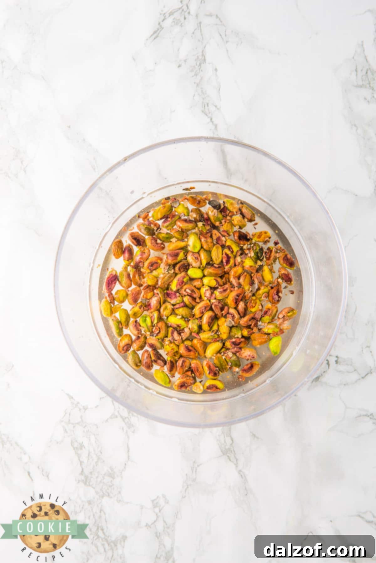 Pistachios soaking in water, a crucial step for hydration before adding them to the cookie dough.