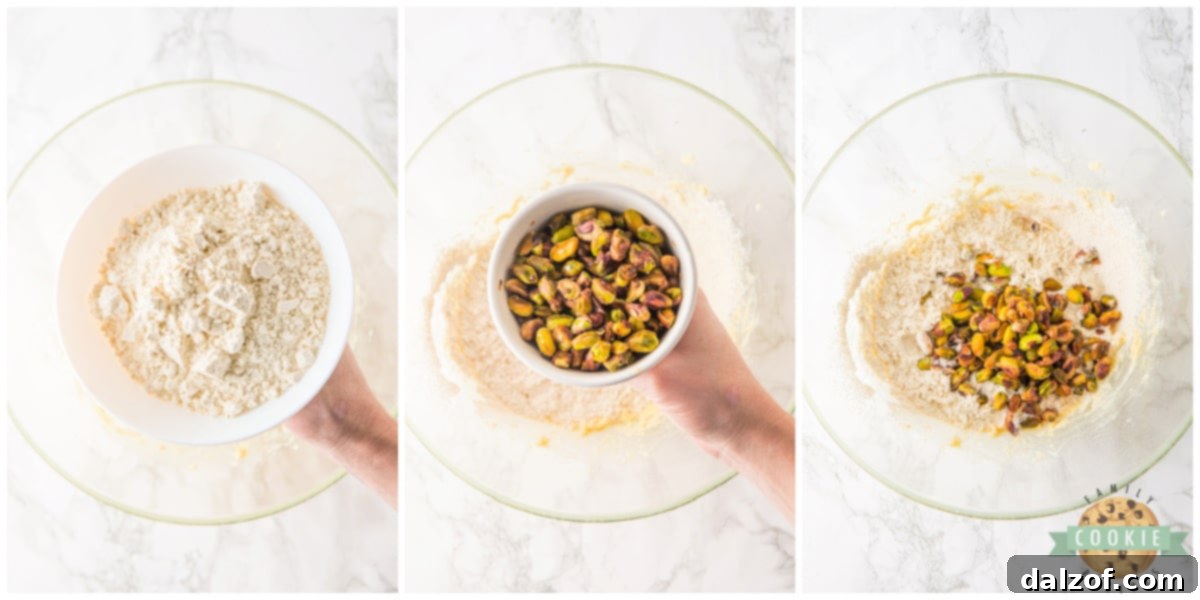 All-purpose flour and hydrated pistachios being gently mixed into the creamy cookie dough until just combined.