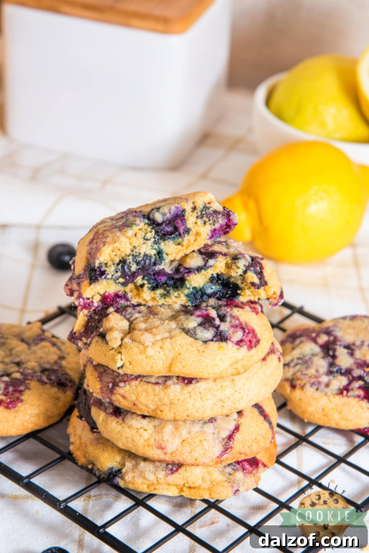 A stack of golden brown lemon blueberry cookies with visible blueberry jam and streusel.
