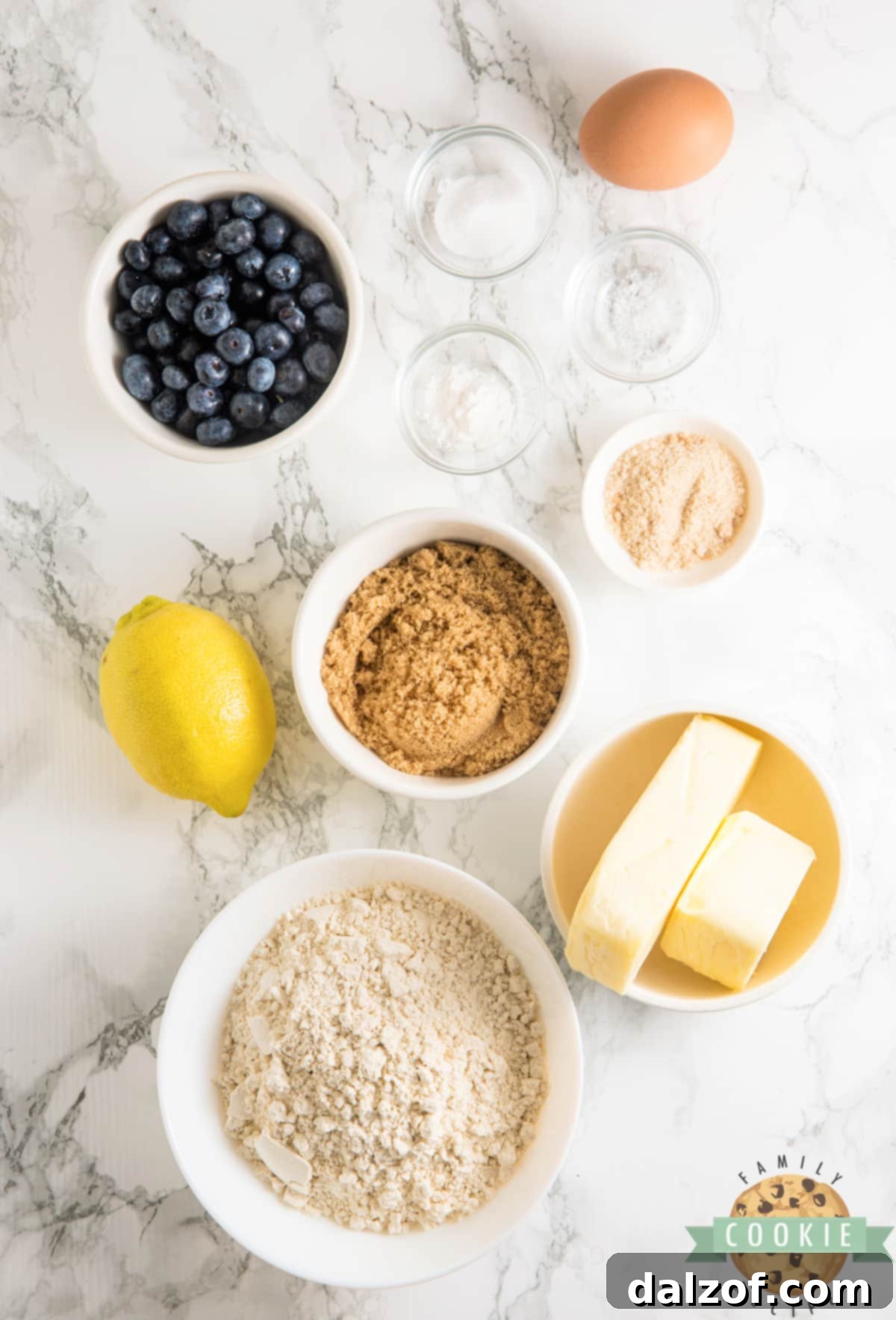 Arranged ingredients for Lemon Blueberry Muffin Cookies on a rustic wooden surface.