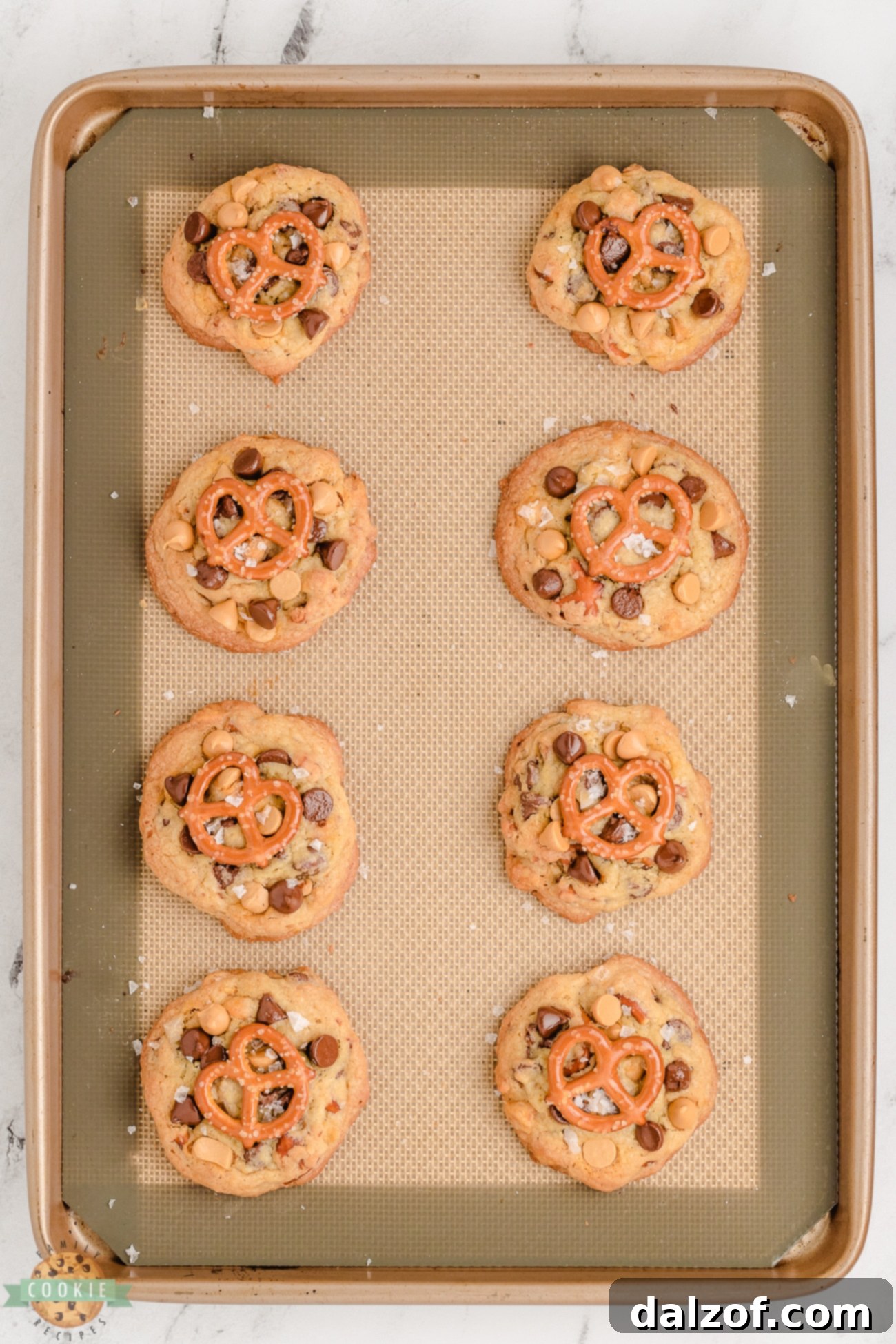 Batch of butterscotch cookies with pretzels on a baking pan, ready to cool