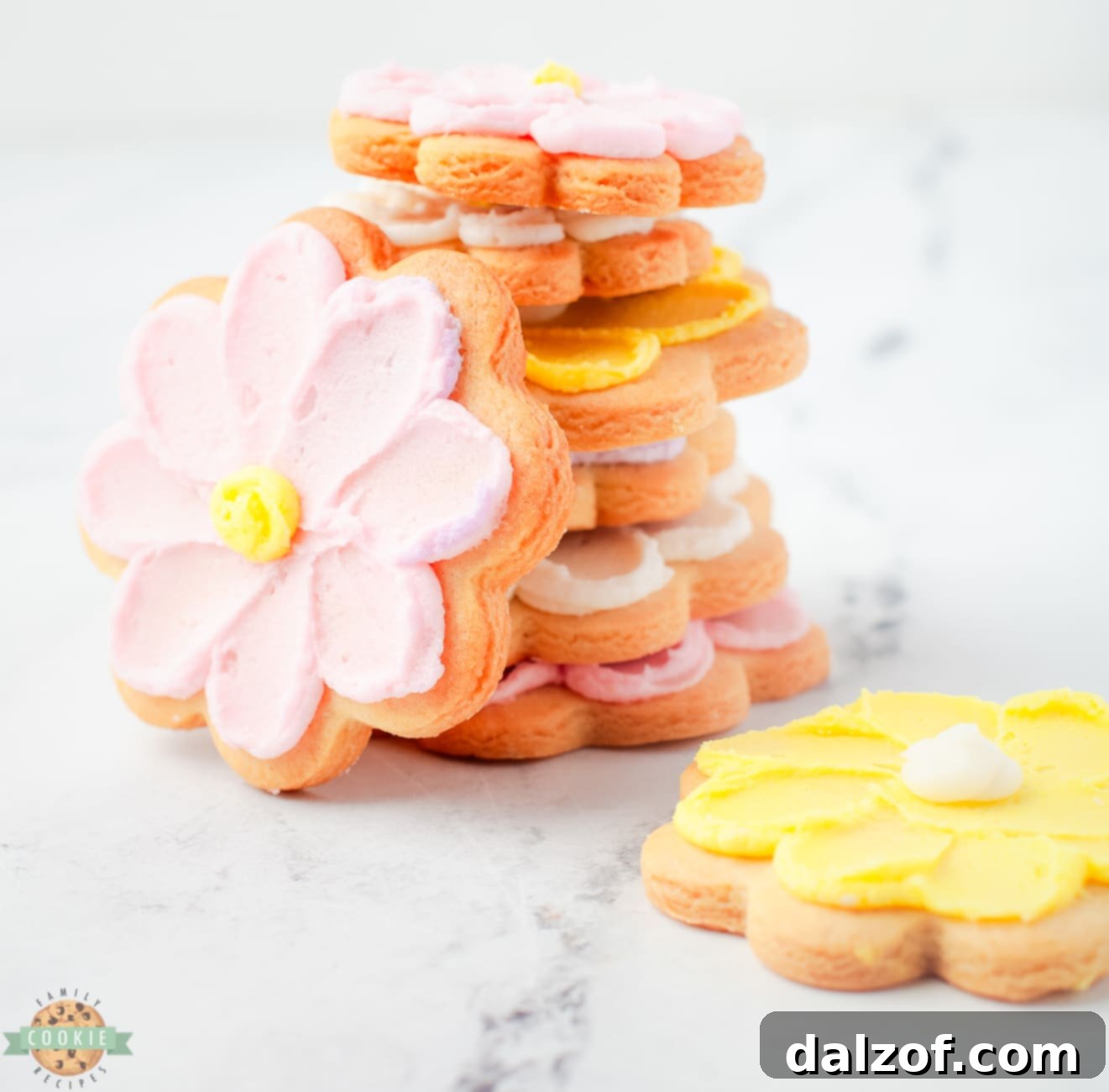 A stack of beautifully decorated buttercream flower cookies, showcasing their intricate designs and appealing colors.
