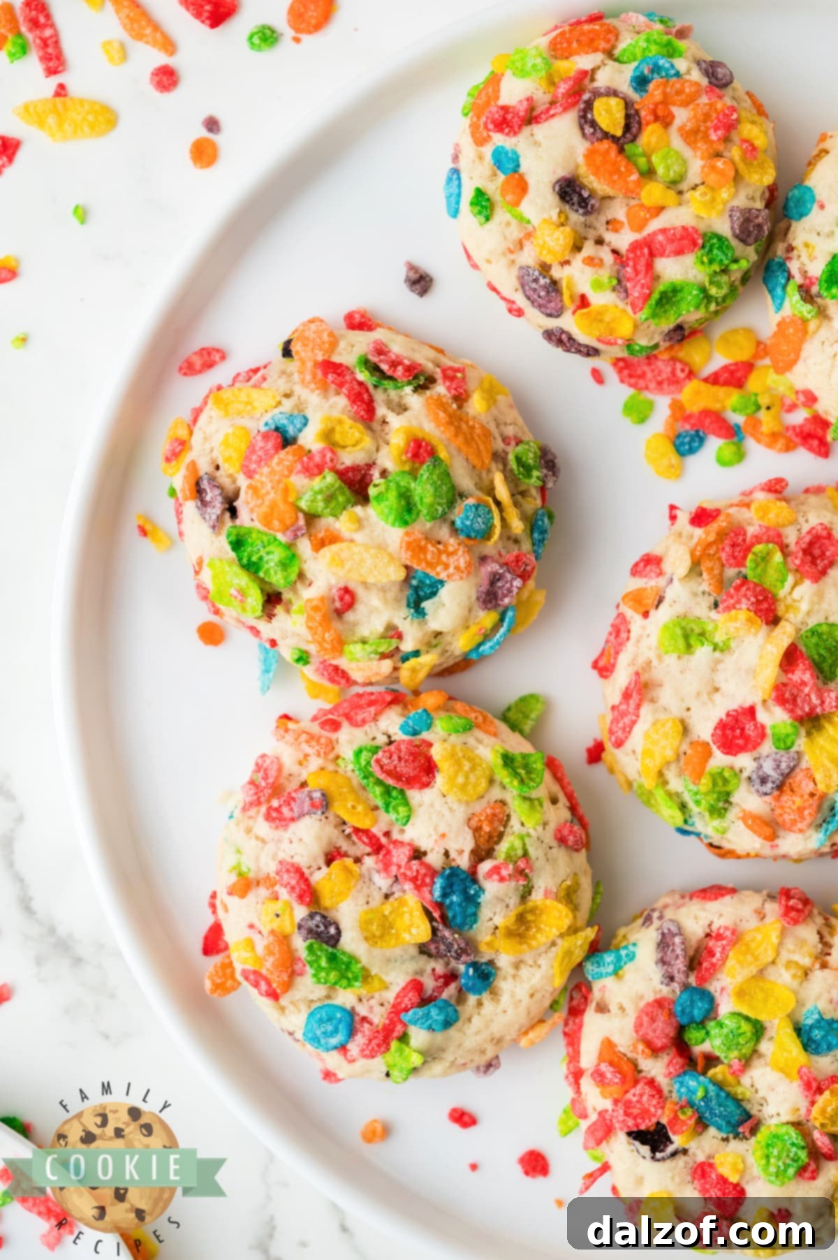 Freshly baked Fruity Pebbles sugar cookies piled high on a white plate.