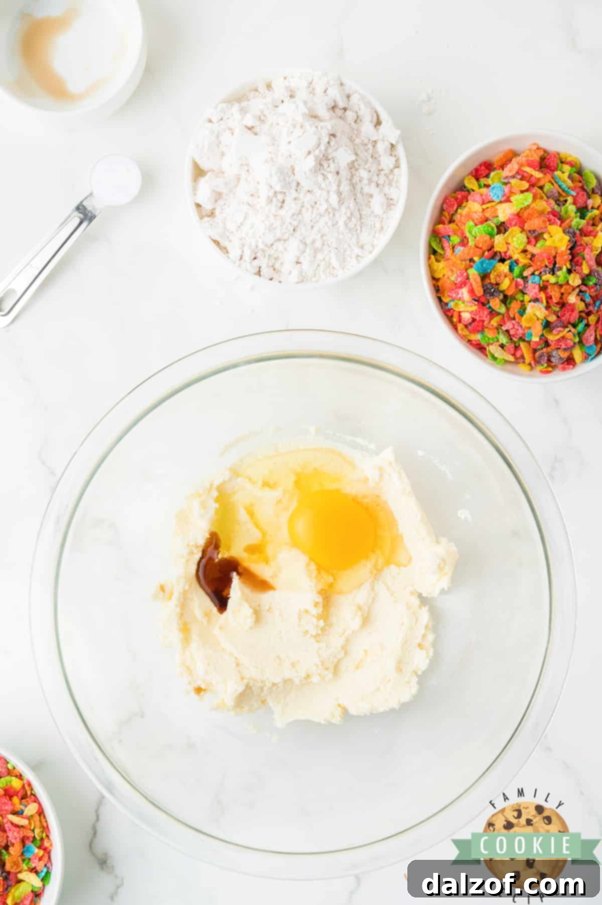 Adding egg and vanilla extract to the creamed butter and sugar mixture.