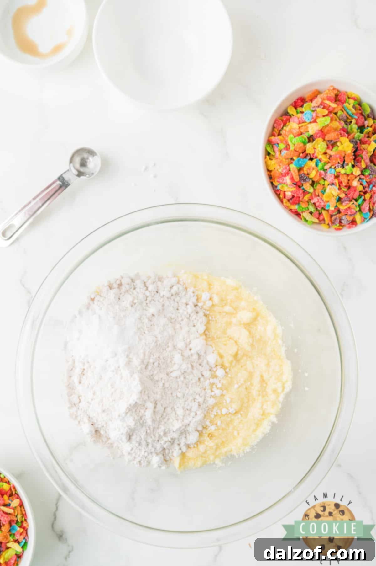 Mixing flour and baking soda into the wet cookie dough mixture.
