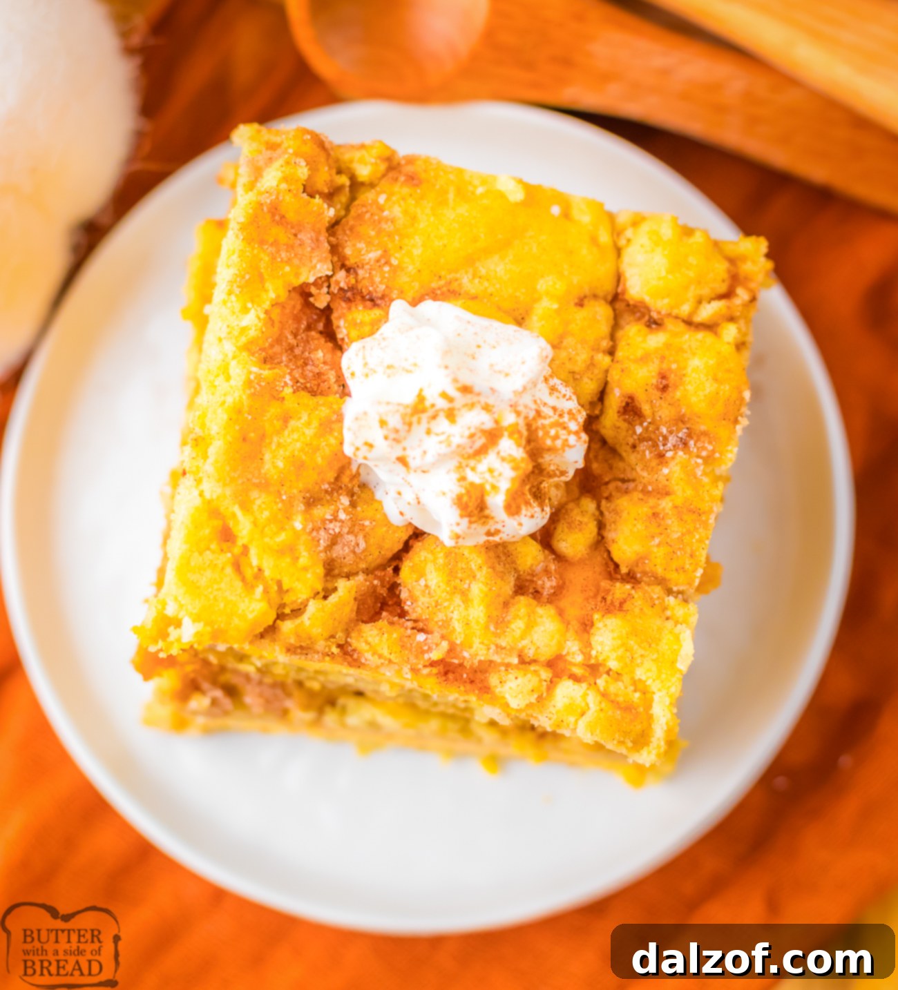 A perfectly portioned slice of Pumpkin Cheesecake Snickerdoodle Bar, showing the distinct layers and a rich, creamy filling.
