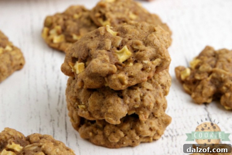 Close-up of golden pumpkin cookies studded with visible pieces of fresh, chopped apples.