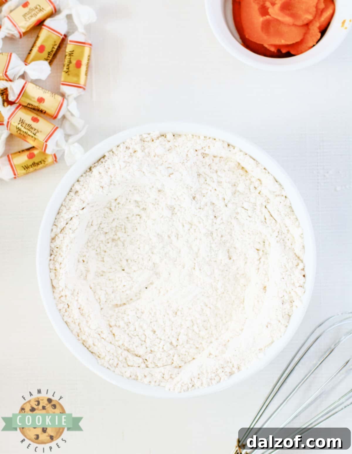 A mixing bowl containing all dry ingredients: flour, baking soda, cream of tartar, cinnamon, nutmeg, ground cloves, and allspice, meticulously whisked together until well combined.