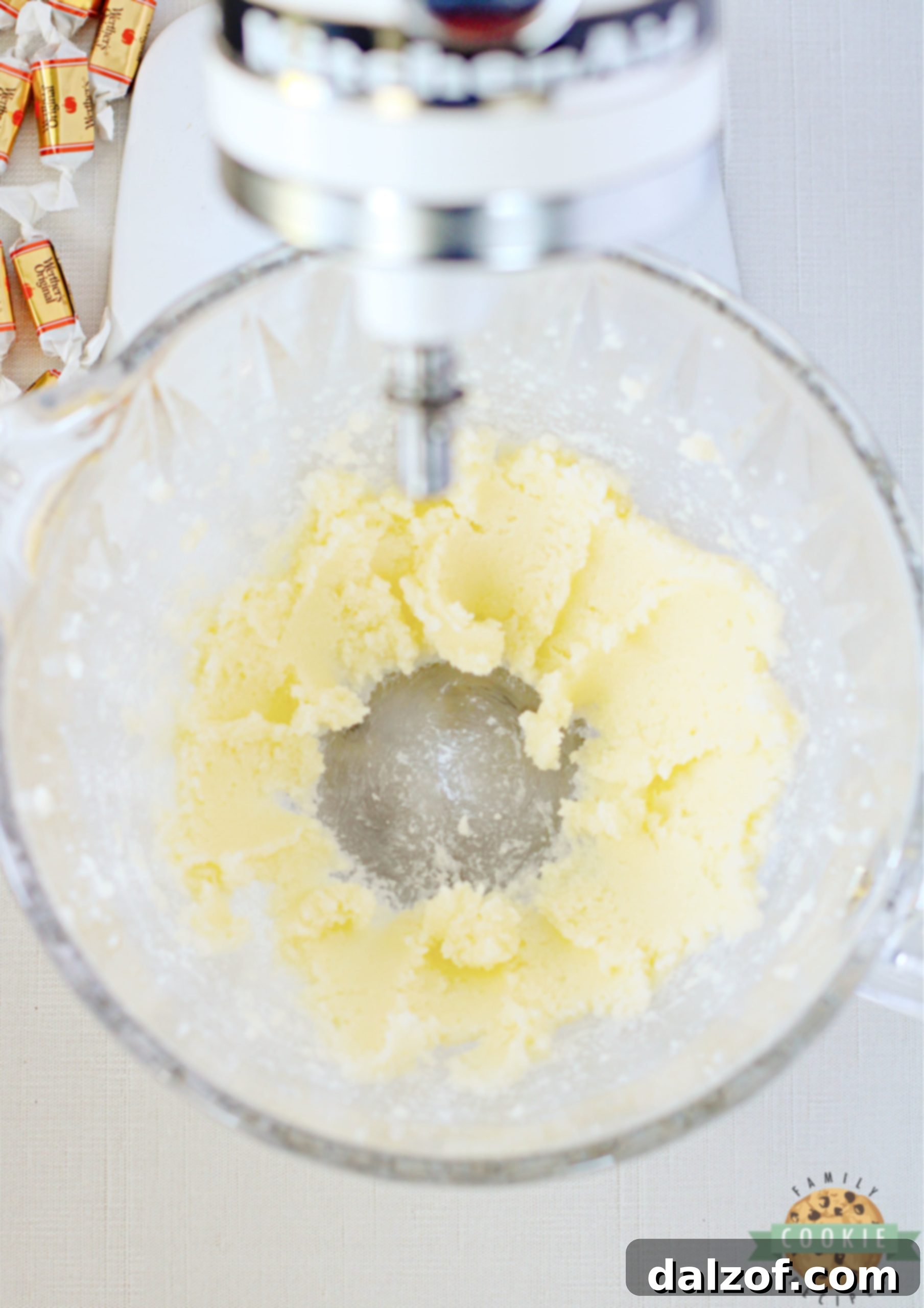 A large mixing bowl showcasing creamy, light-colored butter and granulated sugar, expertly beaten together until fluffy and well combined, indicating proper creaming.