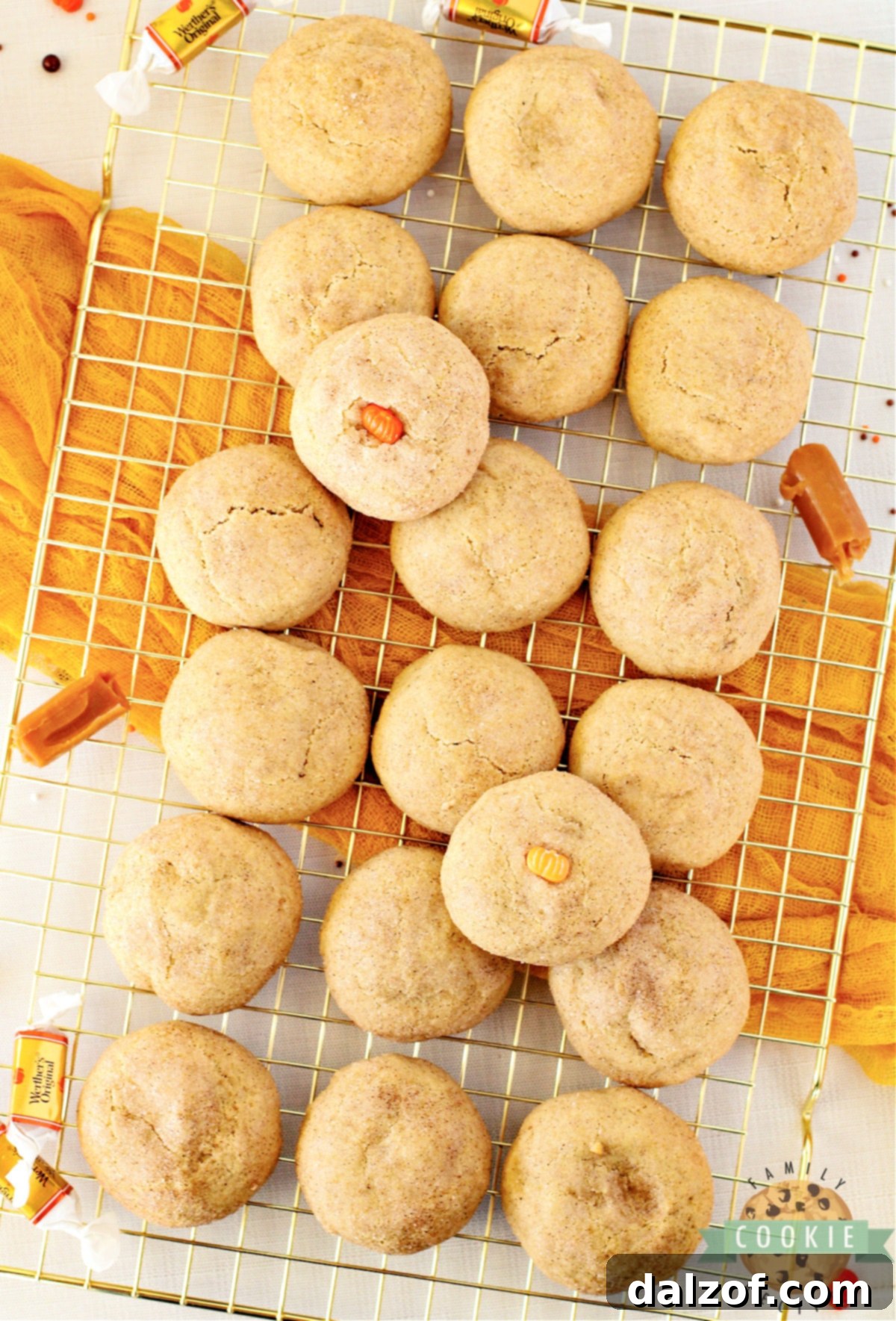A plate of freshly baked Caramel Stuffed Pumpkin Snickerdoodles, with one cookie broken open to reveal its irresistible gooey caramel center, emphasizing it as the ultimate fall cookie.