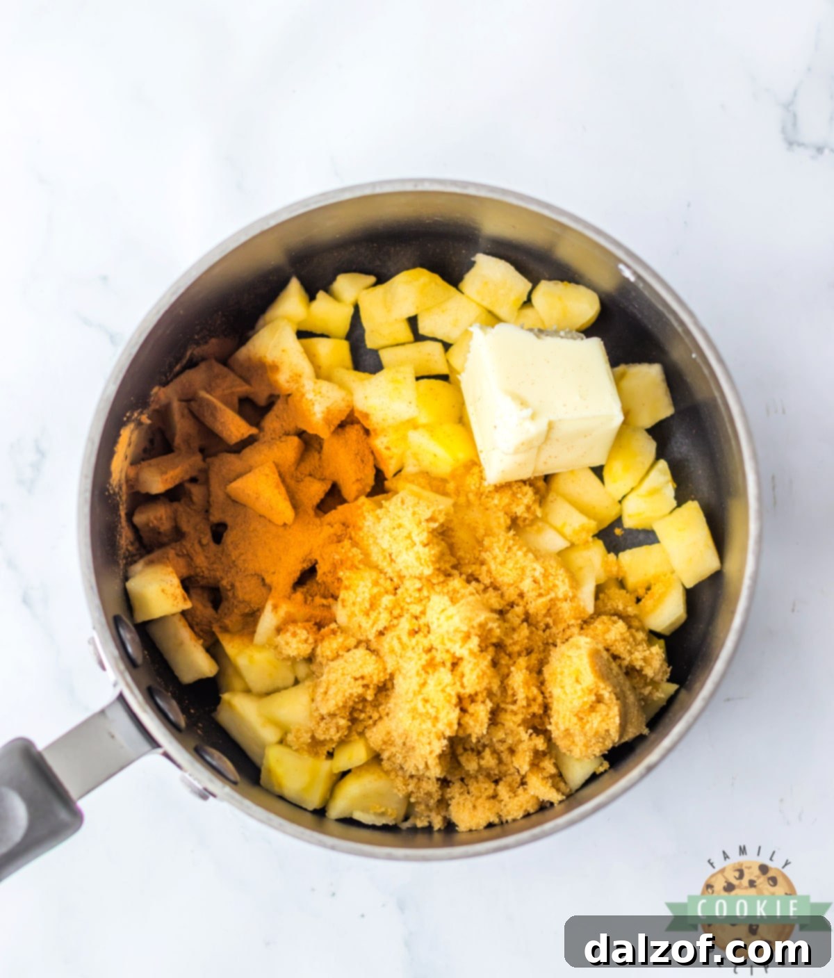 Apples with butter, cinnamon, and brown sugar in a saucepan. 