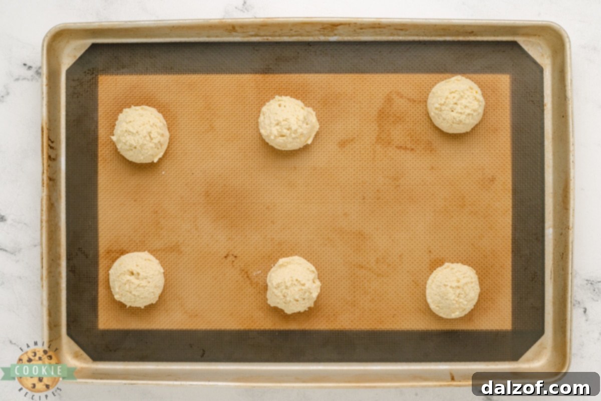 Scooped orange cookies on cookie sheet.