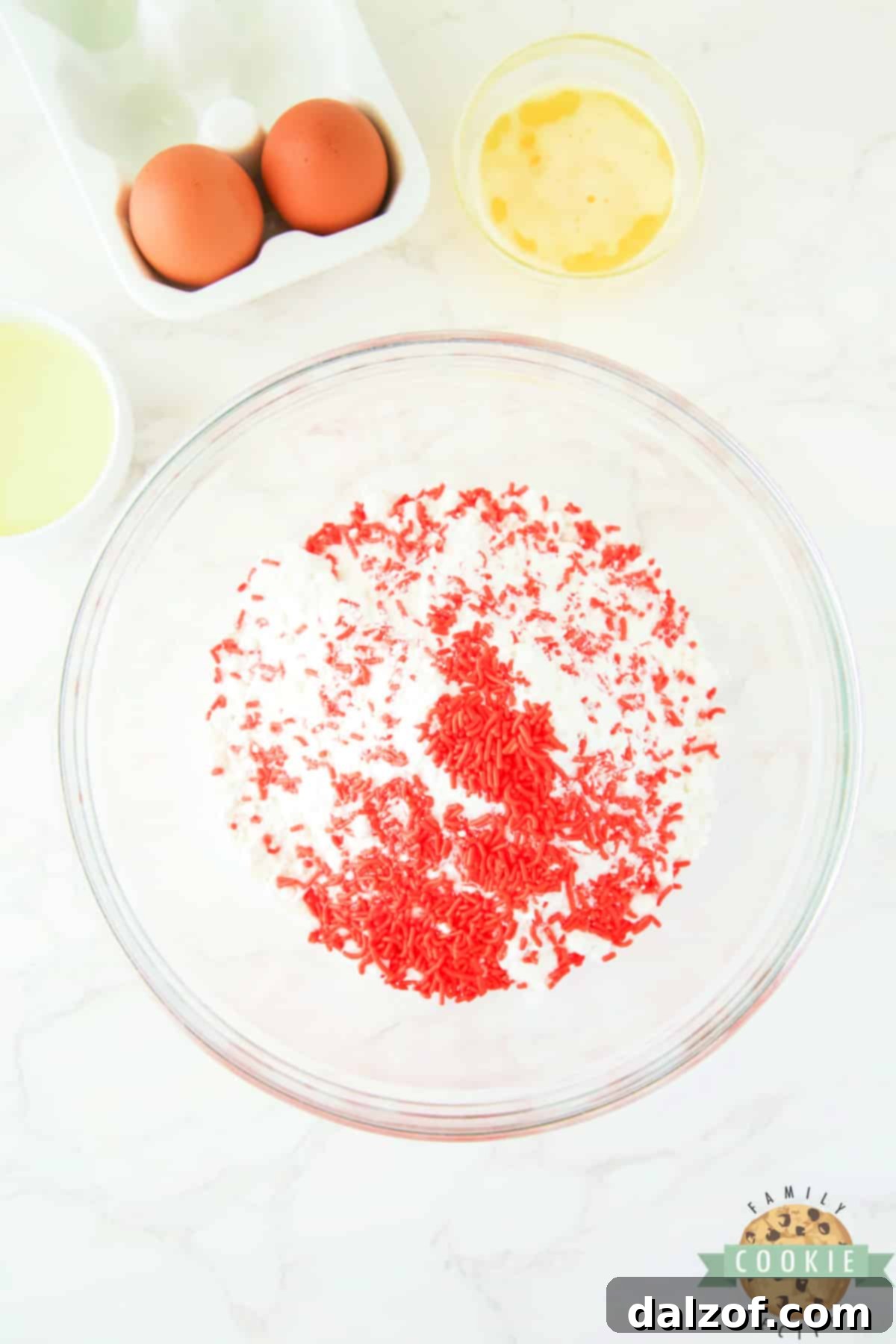 White cake mix with a generous amount of orange sprinkles, ready to be mixed for the cookie dough.
