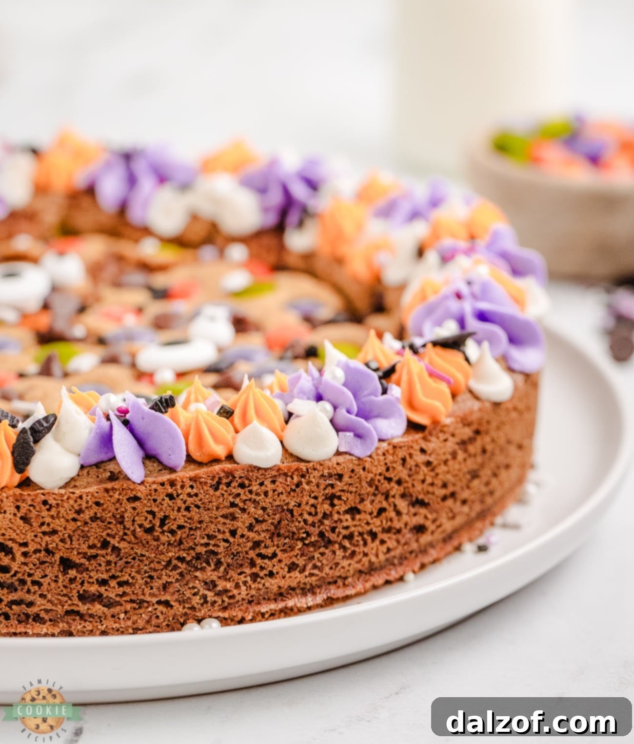 Halloween cookie cake with purple and orange rosette frosting and sprinkles