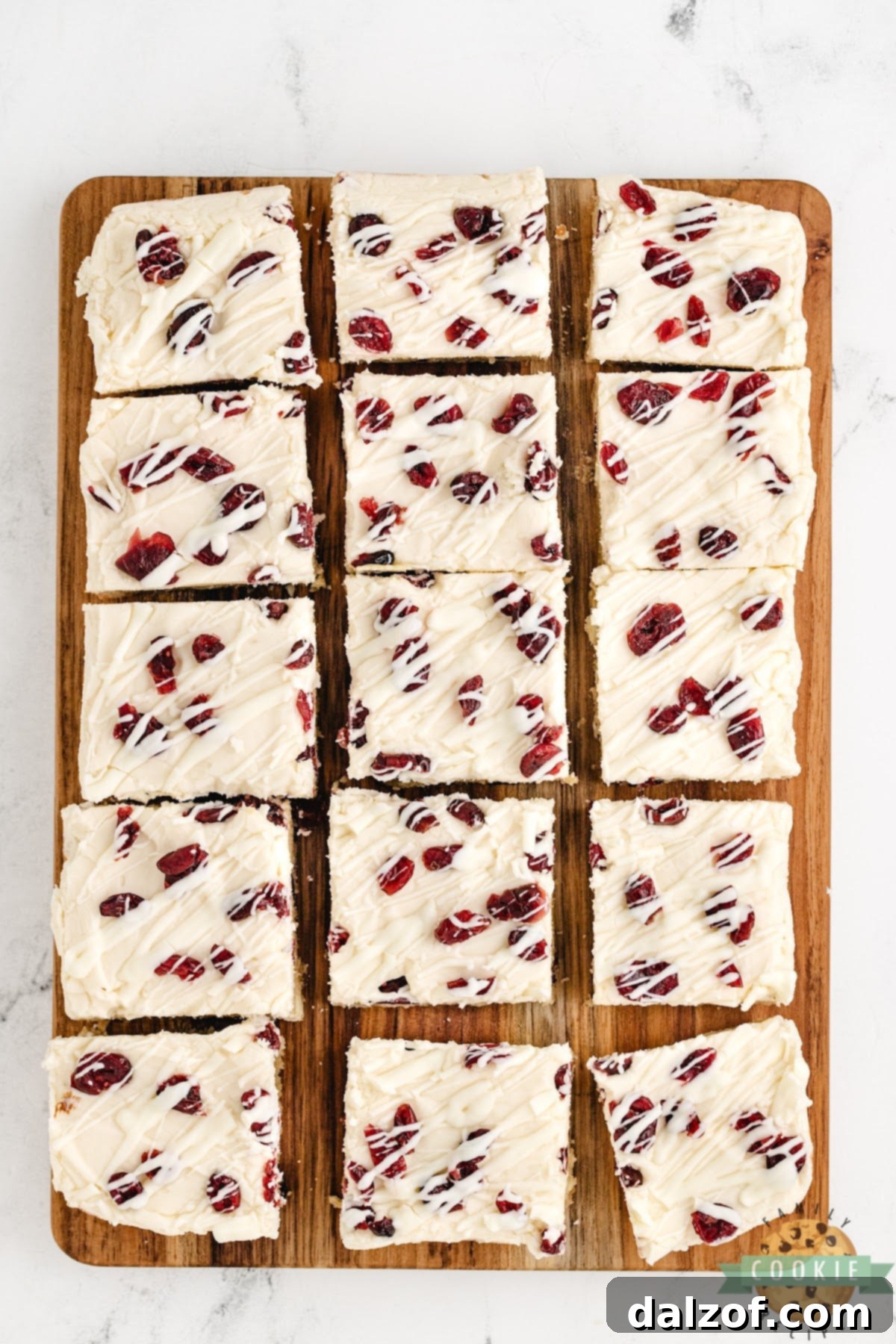 Cookie bars made with cream cheese frosting and dried cranberries.